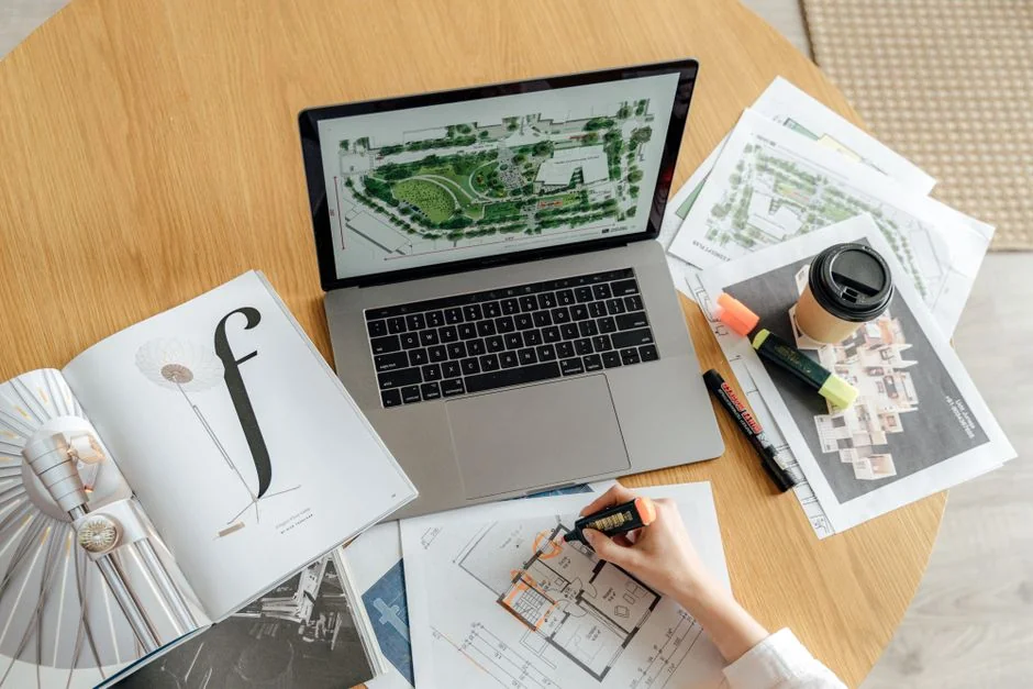 Une équipe variée travaillant ensemble sur des ordinateurs portables dans un bureau moderne, en discutant de l’évolution numérique.